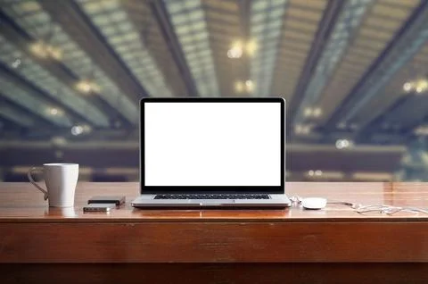 Laptop with blank white screen on table in factory background Stock Photos