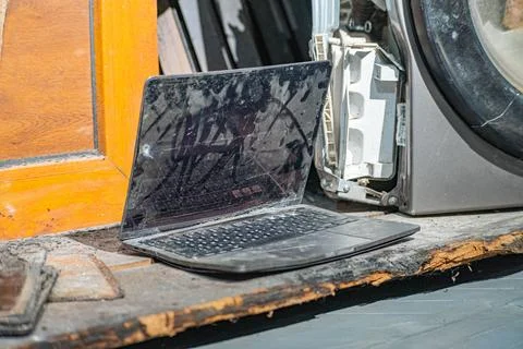 Laptop with a broken screen in cracks on a gray background close up front vie Stock Photos