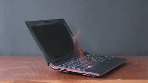 The laptop caught fire on the table, flames and sparks, ignition of the battery  Video stock 170091526