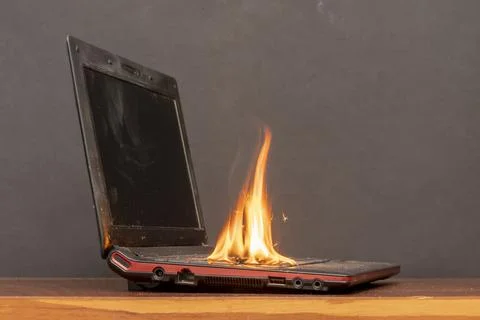 The laptop caught fire on the table, flames and sparks, ignition of the battery  Stock-Fotos