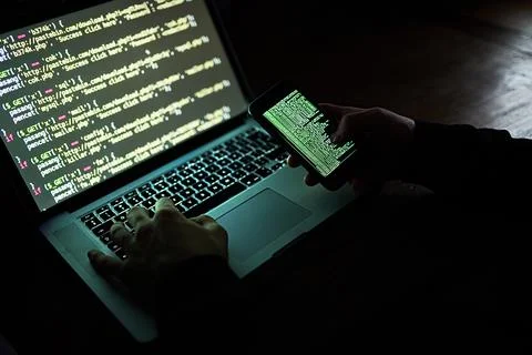 Laptop, cellphone and hands for coding person, hacker or fintech scam for cyber Stock Photos