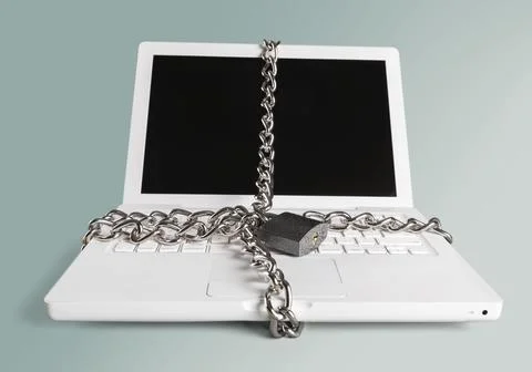 Laptop with chains and padlock on gray background Stock Photos