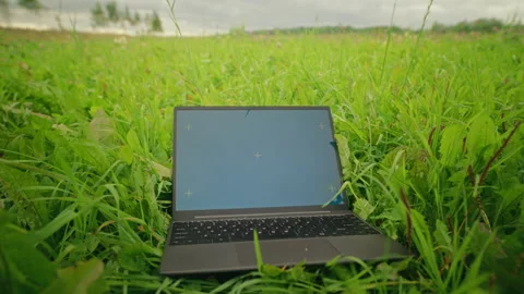Laptop with Chroma Key Screen Resting on Green Grass Field Stock Footage 345463829