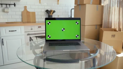 Laptop with chromakey screen on table against paper boxes Stock Footage 201184309
