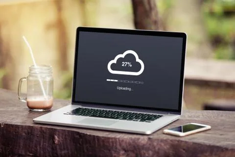 Laptop with cloud uploading concept on screen in the park / garden with phone  Stock Photos