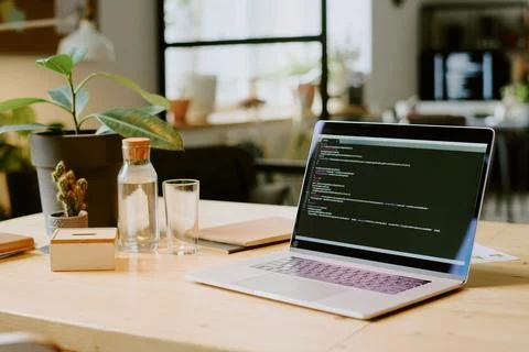 Laptop With Code On Screen In Office Stock Photos