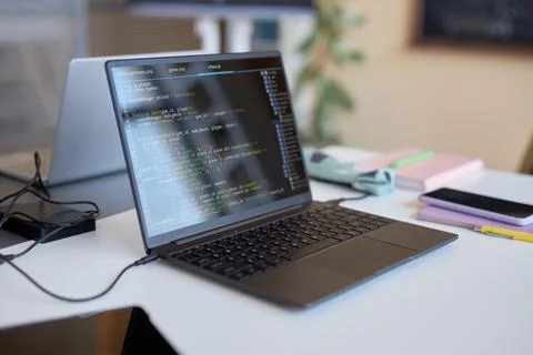 Laptop with codes on screen standing on desk of highschool student Stock Photos