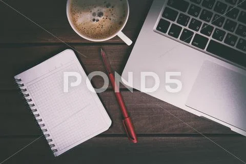Laptop, coffee cup and notebook on wood table Stock Photos