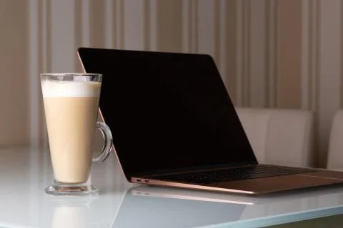 Laptop with a coffee latte on the table Stock Photos