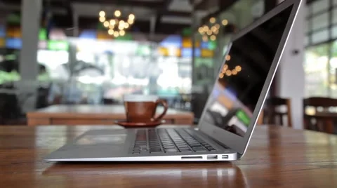 Laptop computer and cup of coffee on a table in cafe Stock Footage 49710567