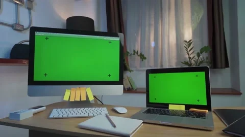 Laptop Computer and Desktop Computer Showing Green Key Screen Stands on a Desk Stock Footage 157757223