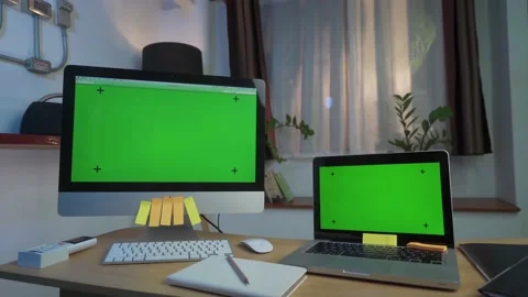 Laptop Computer and Desktop Computer Showing Green Key Screen Stands on a Desk Stock Footage 157757232