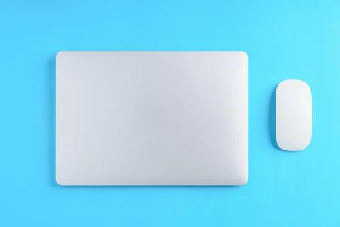 Laptop computer and mouse on blue background above view Stock Photos