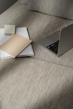 Laptop computer and office documents on comfortable sofa with sunlight shadow Stock Photos