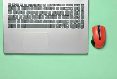 Laptop computer and red mouse on green background Stockfoto's