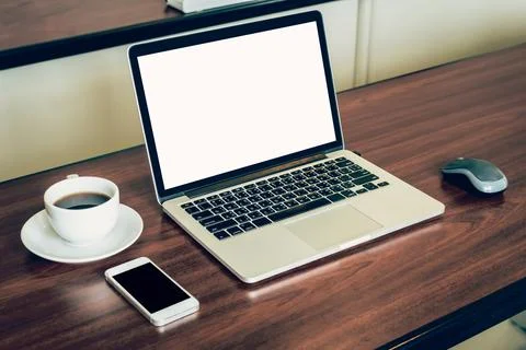 Laptop computer and white blank screen on wood table in office. Stock Photos