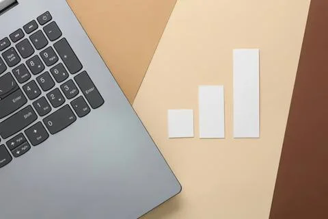 Laptop computer with bar chart on beige background Stock Photos