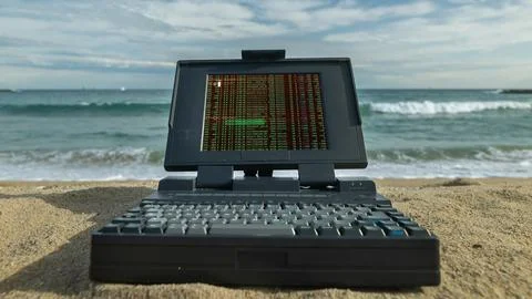 Laptop computer on a beach with data and code on screen Foto stock