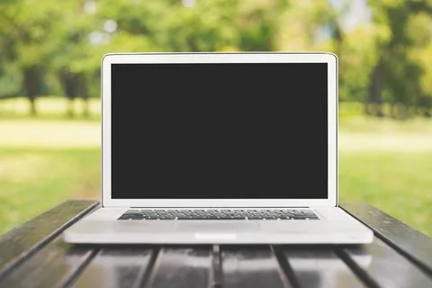 Laptop computer with blank black screen on green nature background. Natural.. 스톡 사진