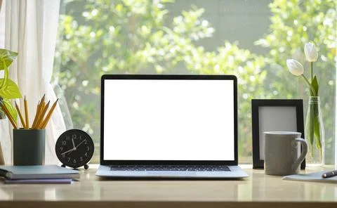 Laptop computer with blank display, coffee cup, pencil holder and picture fra Foto stock
