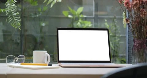 Laptop computer with blank display, eyeglasses, coffee cup and notebook on .. Stock Photos