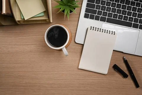 Laptop computer, blank notepad, pen and coffee cup on wooden tale. Flat lay, Top Stock Photos