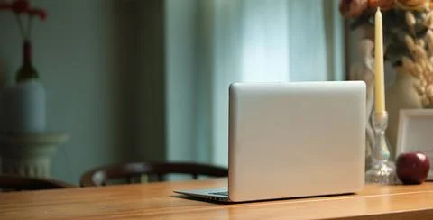 Laptop computer with blank screen, bouquet of fresh flowers in vase and can.. Stock Photos