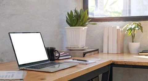 Laptop computer with blank screen, coffee cup on table Comfortable workplace. Stock-Fotos