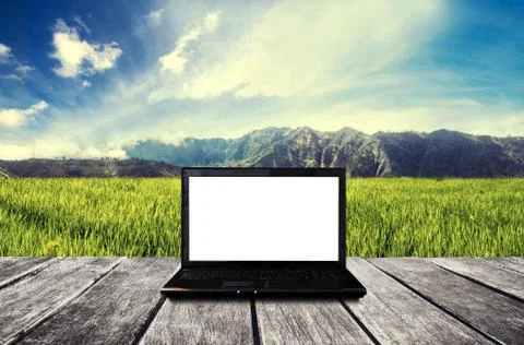 Laptop computer blank white screen, on wood table at countryside Stock Photos