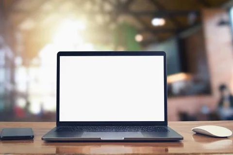Laptop computer blank white screen and mobile on table in cafe background Foto stock