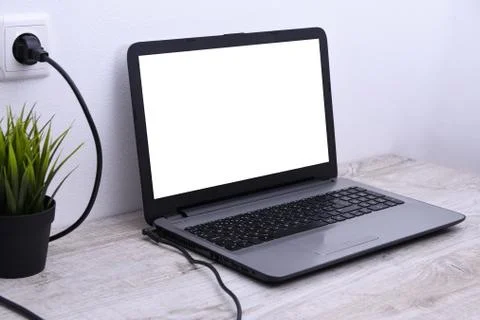Laptop, computer is charging from a 220-volt outlet on a desk near the wall. 스톡 사진