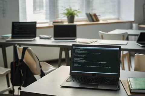 Laptop with computer codes on table at class Stock Photos