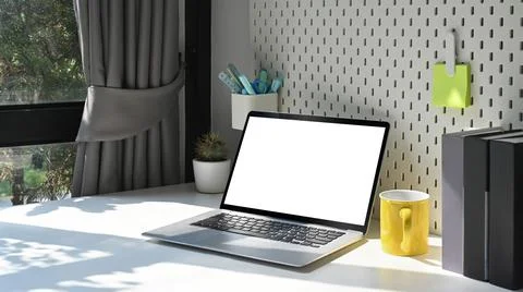 Laptop computer, coffee cup and supplies on white table. Home office workplace Stock Photos