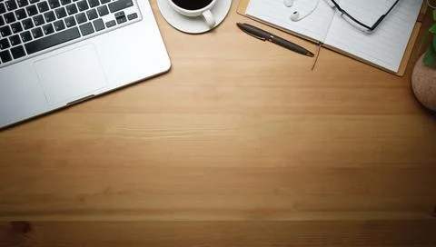 Laptop computer, coffee cup, notebook and glasses on wooden background. Top.. Stock Photos
