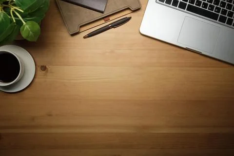 Laptop computer, coffee cup, notebook and potted plant on wooden background.. Stock Photos