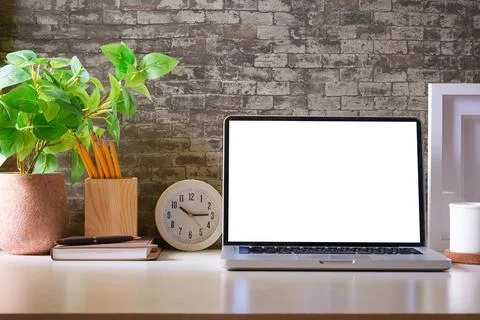 Laptop computer, coffee cup, potted plant and picture frame on creative wor.. Stock Photos