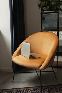 Laptop computer on comfortable orange lounge chair Stockfoto's