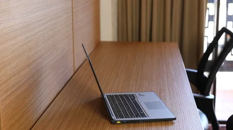 Laptop computer on desk in office with daylight coming through Stock Footage 45938044