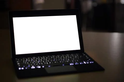 Laptop computer displaying white background. PC on a table in a office room. Stock Photos