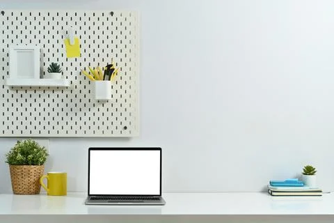 Laptop computer with empty display, coffee cup, houseplant and books on white Stock Photos