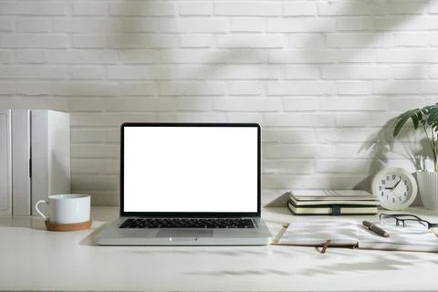 Laptop computer with empty display, picture frame and stationery on wooden .. Stock Photos