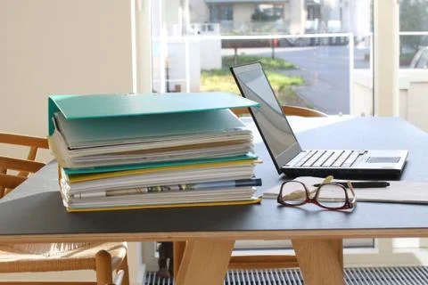 Laptop computer, glasses, paper sheets, pencil and ring binders Stock Photos