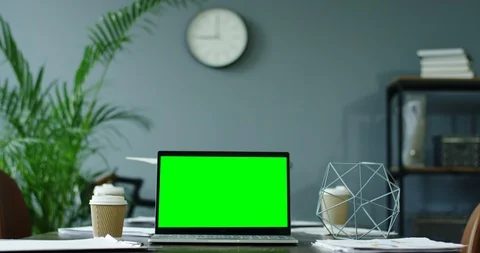 Laptop computer with green screen and coffee to-go on the desk in the cozy Stock-Footage 104977226