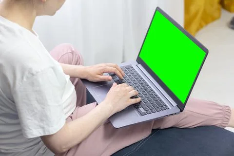 A laptop computer with a green screen image on which a pregnant girl works Foto stock