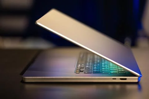 A laptop computer with a half-open screen on a dark background. Stock Photos