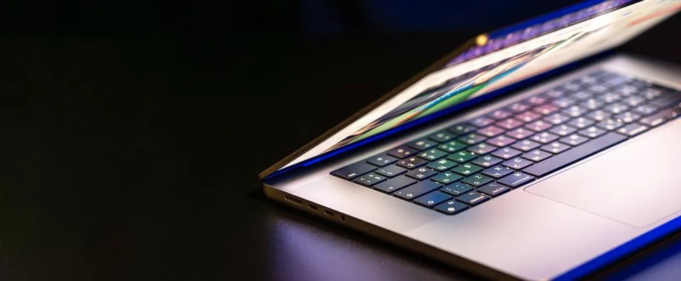 A laptop computer with a half-open screen on a dark background. Copy space. Foto stock