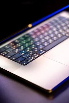 A laptop computer with a half-open screen on a dark background. Stockfoto's