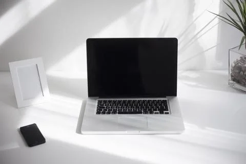 Laptop computer with isolated screen is on the table with a cup of coffee in a w Foto stock