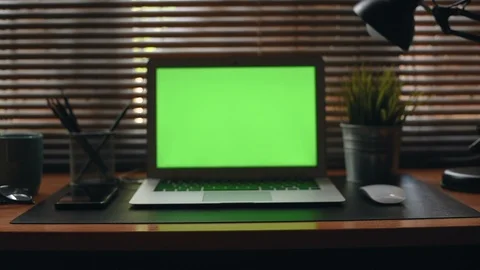 A laptop computer with a key green screen set on work office table. Vidéo 98221109
