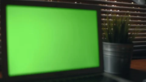 A laptop computer with a key green screen set on work office table. Stockbeeldmateriaal 98221184